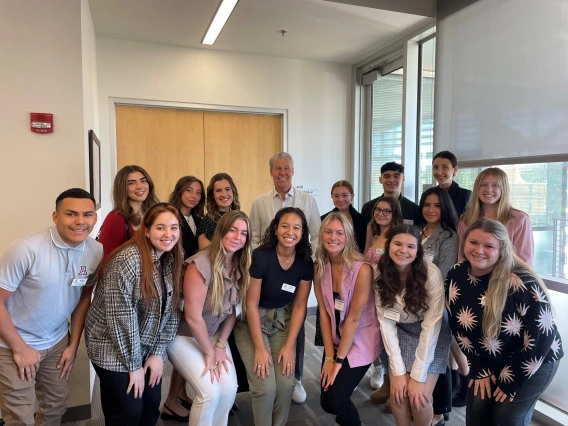 Students with Terry J. Lundgren smiling at camera